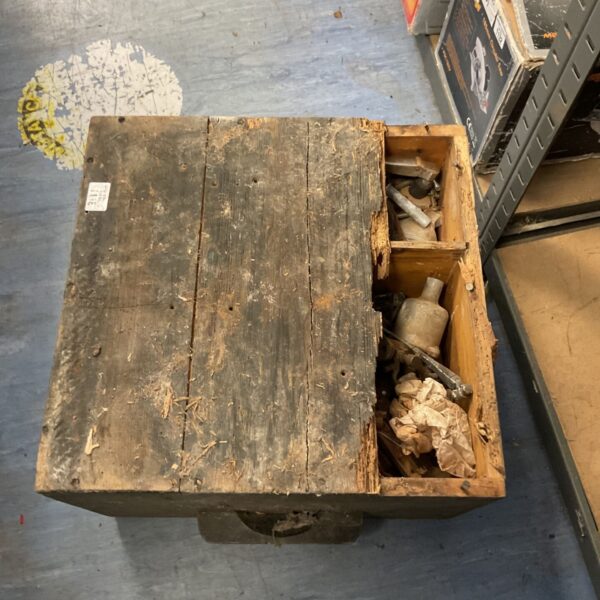 Vintage wooden tool box filled with various tool items.