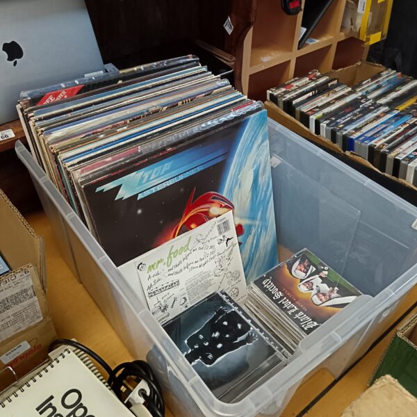 Vinyl record collection including ZZ Top albums in storage container.