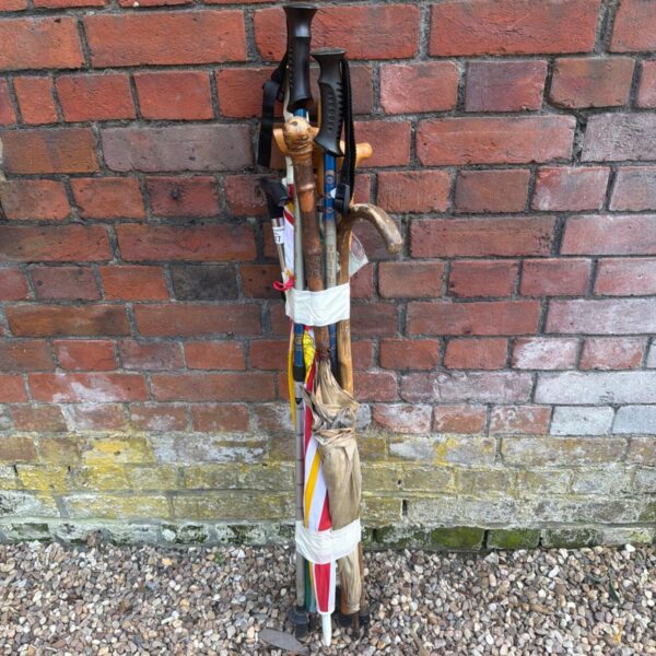 Bundle of vintage walking sticks and umbrellas for collectors.