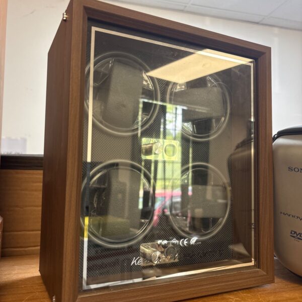 Dark woodgrain watch winder case with four positions for automatic watches.