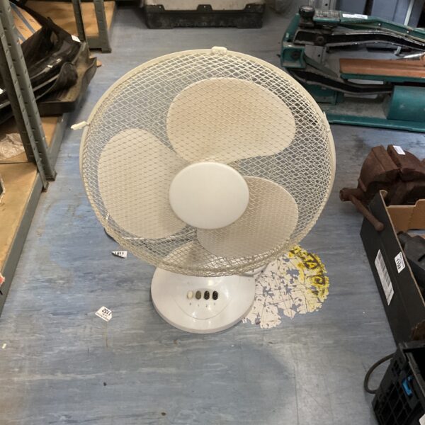White oscillating desk fan on a table, vintage style.