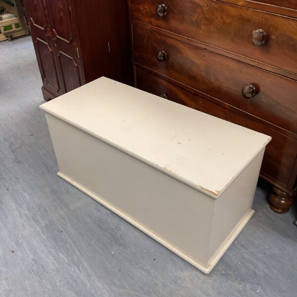Vintage white storage trunk for blankets and linens.