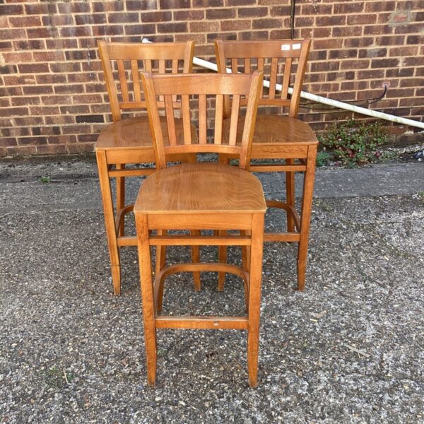 Vintage wooden bar stools with six-slat backs for kitchen seating.