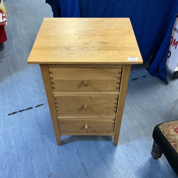 Wooden three-drawer bedside table for bedroom storage.