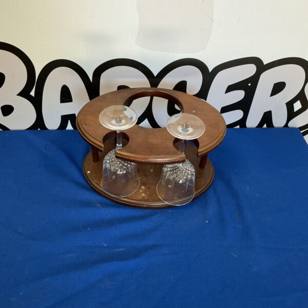 Wooden bottle holder displaying two glasses on a dark surface.