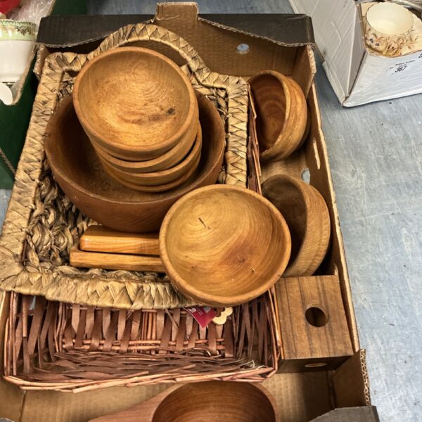 Assorted wooden bowls presented in a woven basket.