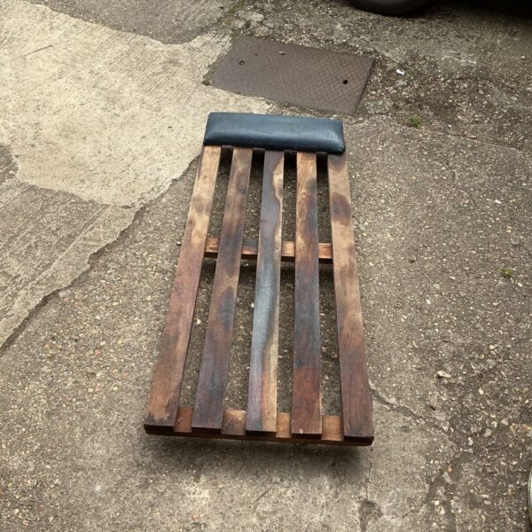Vintage wooden mechanics crawler board for automotive repairs.