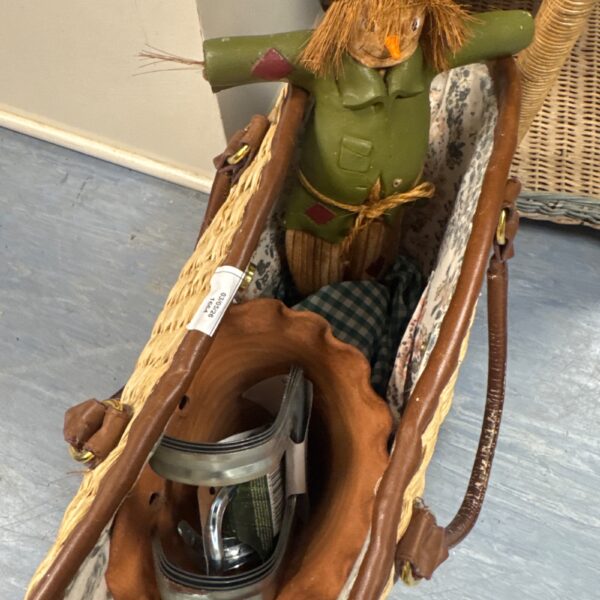 Vintage woven straw gardening bag with scarecrow ornament inside.