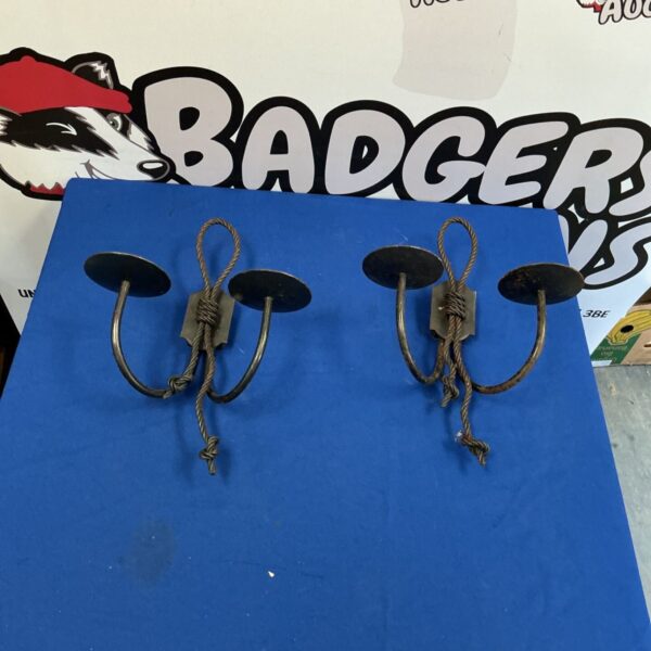 Vintage wrought iron candle holders mounted on a wall.