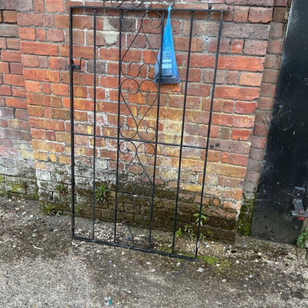 Antique wrought iron garden gate with decorative metalwork.