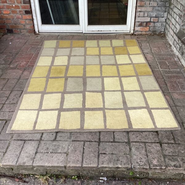 Vintage yellow and grey patterned rug with a geometric tiled design.