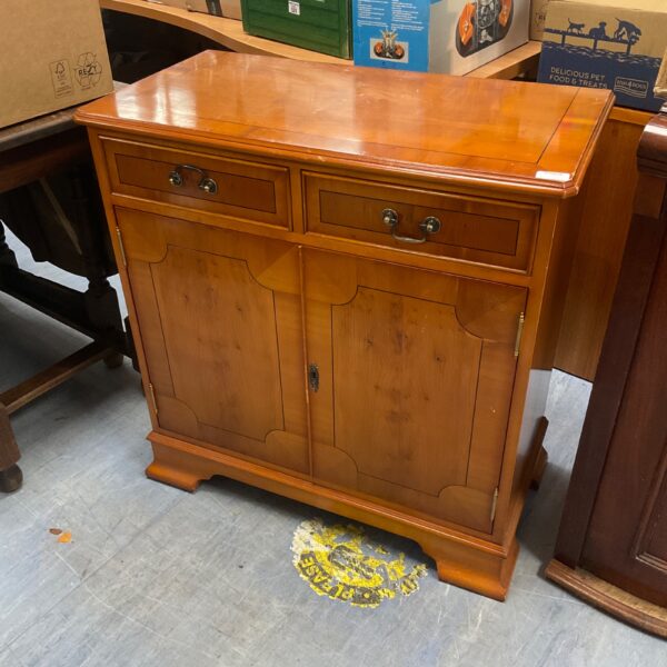 Antique yew wood cabinet with two drawers and cupboards.