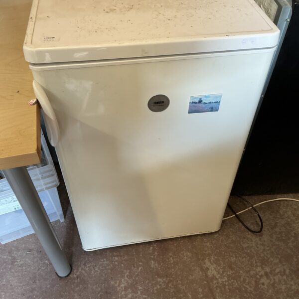 White Zanussi fridge with signs of wear and age.