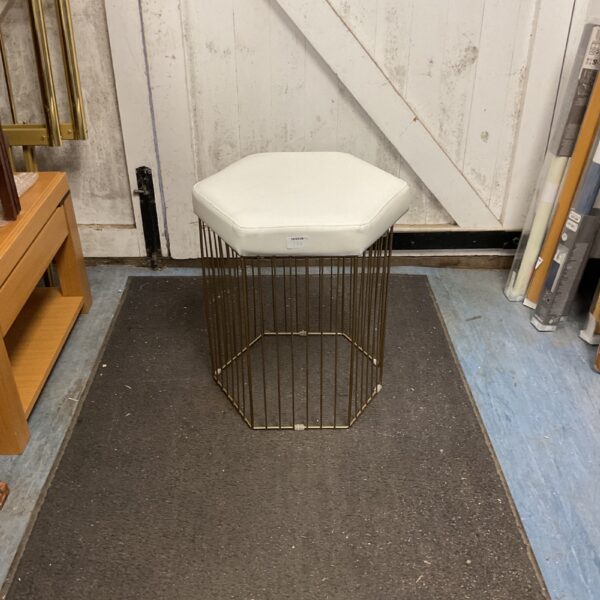 Gold geometric Zuiver Queenbee side table with neutral seat.