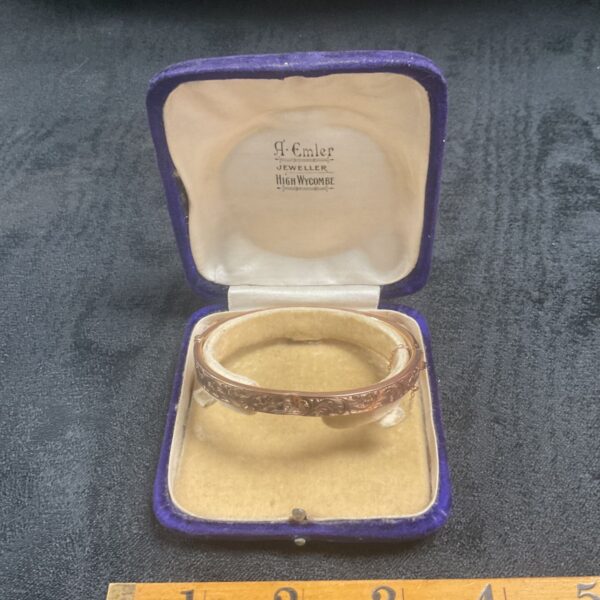 Open presentation box displaying a 9ct gold foliate engraved bangle.
