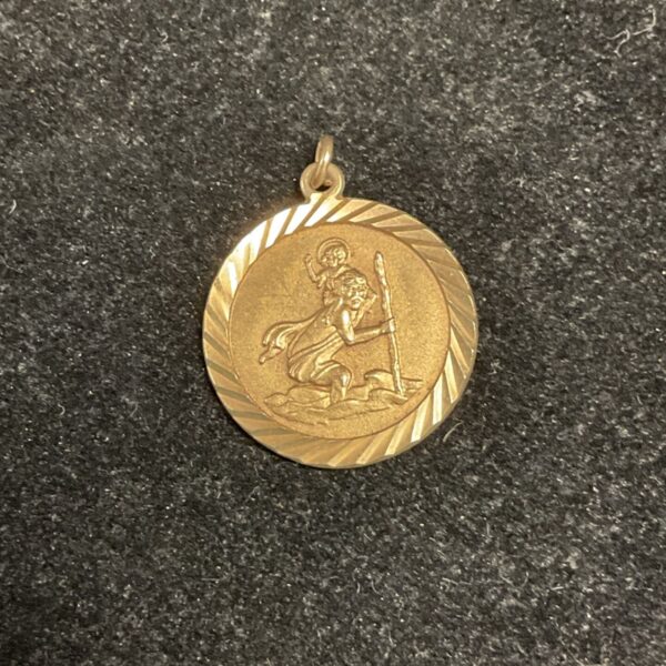 Close-up of 9ct gold St Christopher pendant with detailed relief.