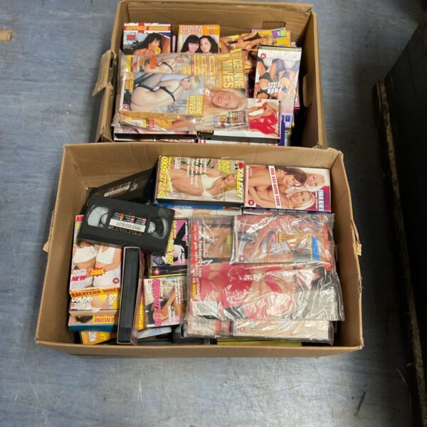Two boxes filled with adult VHS tapes, a vintage video collection.