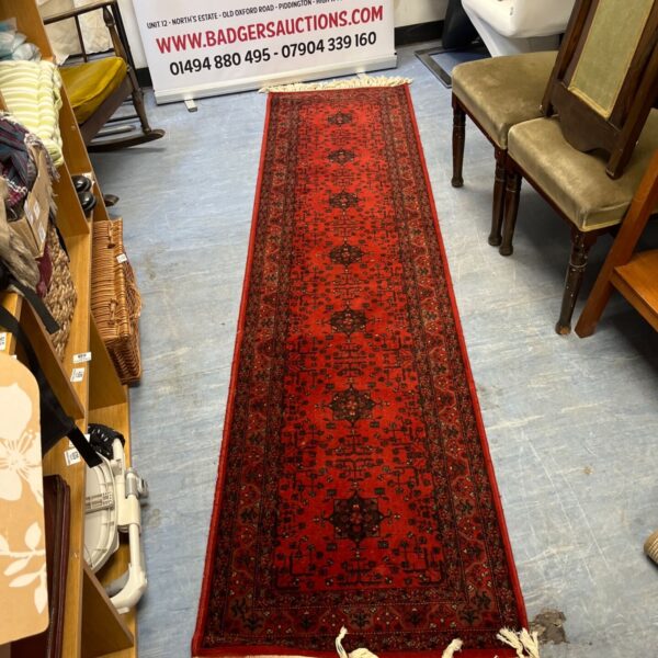 Red Afghan Bukhara runner with tribal geometric design.