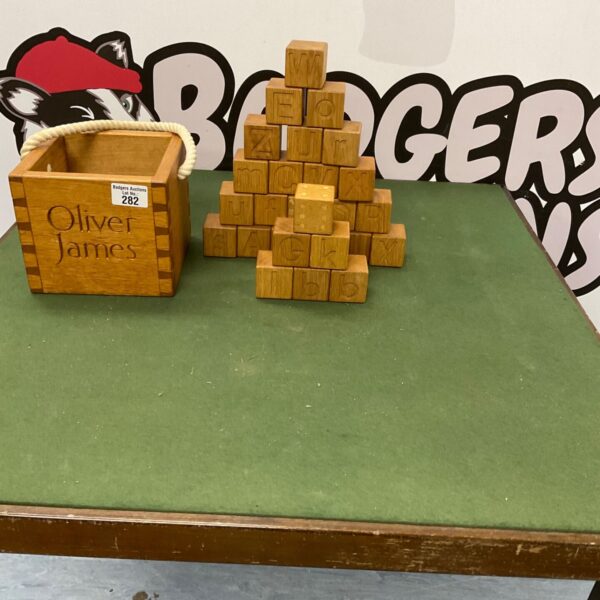 Vintage wooden box filled with alphabet blocks and dice for children's learning.