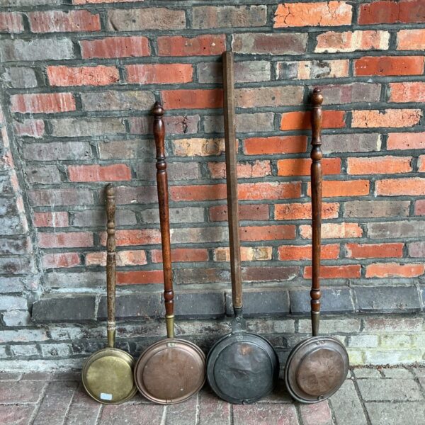 Group of four antique copper and brass bed pan warmers.