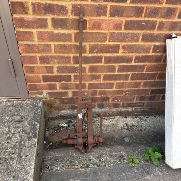 Antique metal bench clamp showing rust and wear.