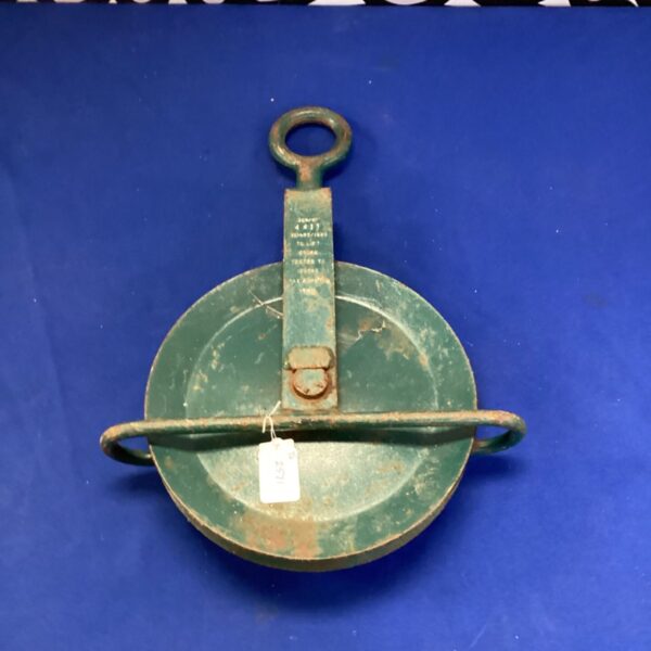 Antique block and tackle pulley with green paint.