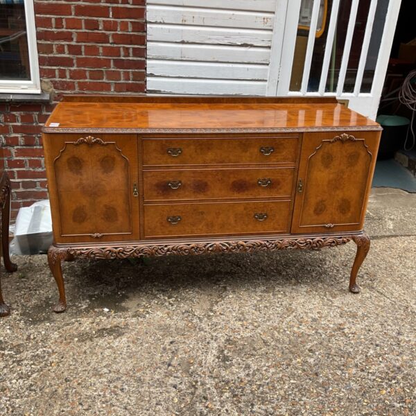 Antique burr walnut sideboard with detailed carving and warm tones.