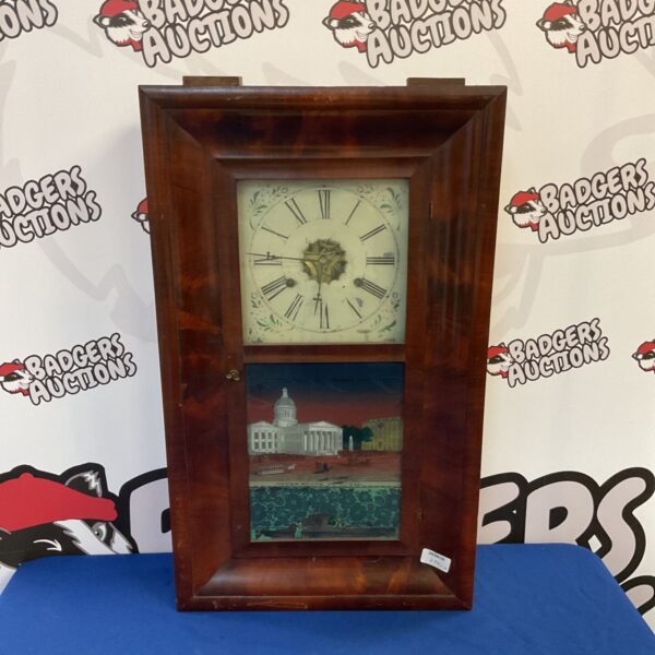 Antique E N Welch clock with a glass front and painted scene.