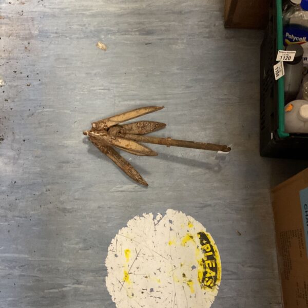Antique grapnel anchor with multiple flukes, showing signs of age.