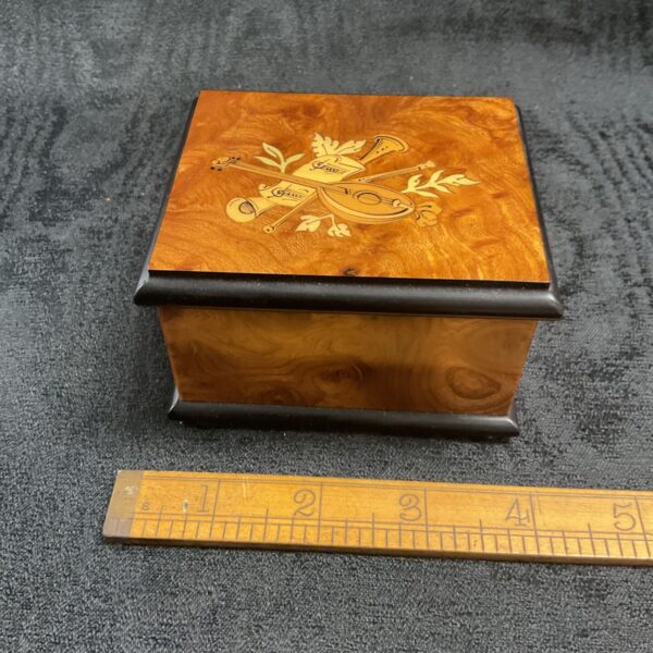 Antique wooden music box with inlaid floral design.