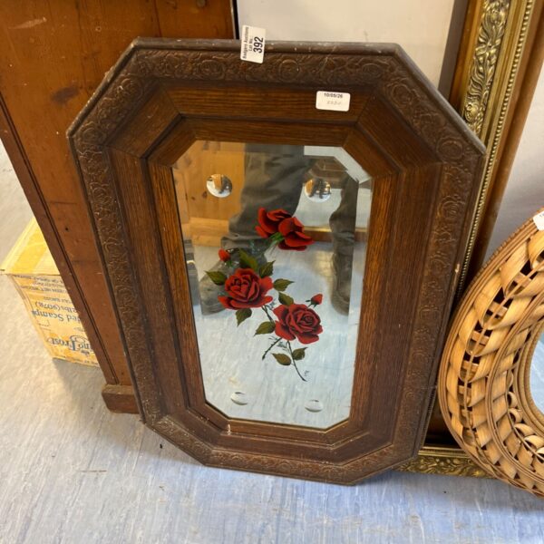 Antique octagonal wall mirror with carved oak frame and rose detail.