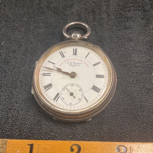 Antique silver pocket watch with white enamel dial.