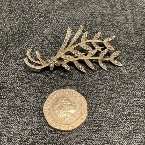 Antique silver marcasite brooch with a floral design.