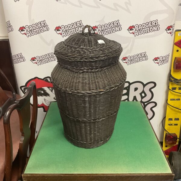Dark brown antique wicker washing bin with a unique shape.