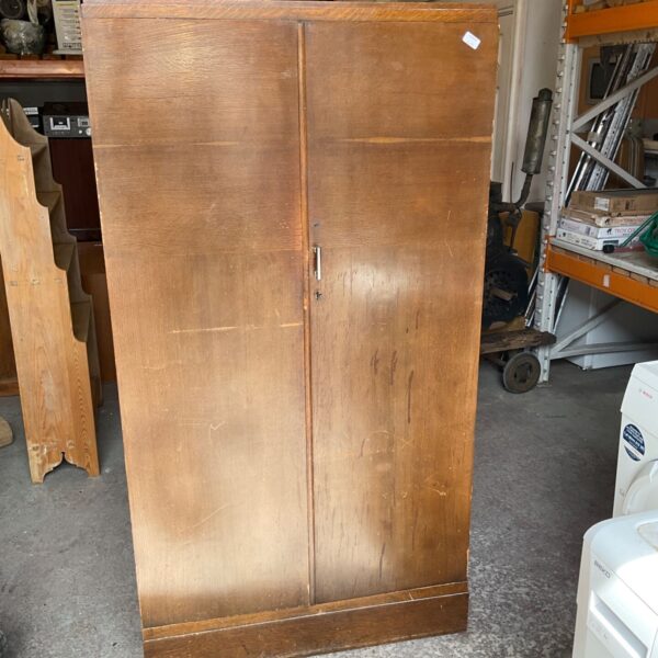 Vintage Art Deco wardrobe with wooden doors and moulded detailing.