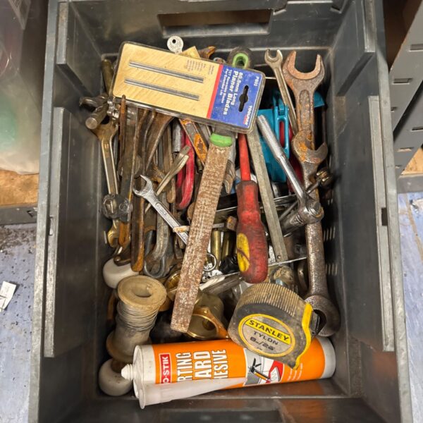 Assorted hand tools in a box, including wrenches and screwdrivers.