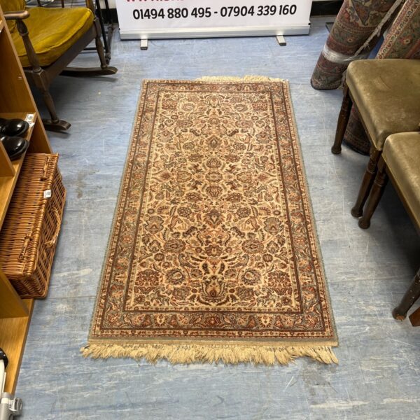 Beige and brown Persian rug with floral pattern and knotted fringe.