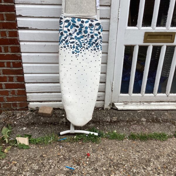 Bellway ironing board with patterned cover, folded and ready for use.