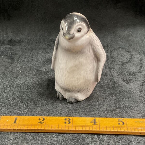 Vintage John Beswick baby penguin figurine with ruler for scale.