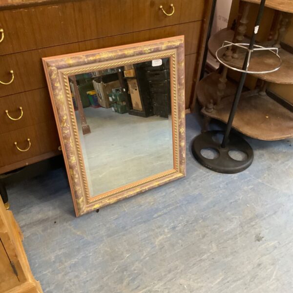 Vintage bevel edge mirror with ornate gilded frame.