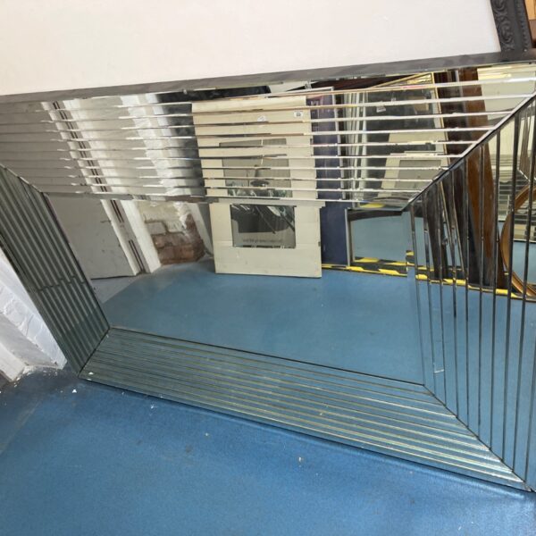 Geometric beveled glass wall mirror with layered frame.