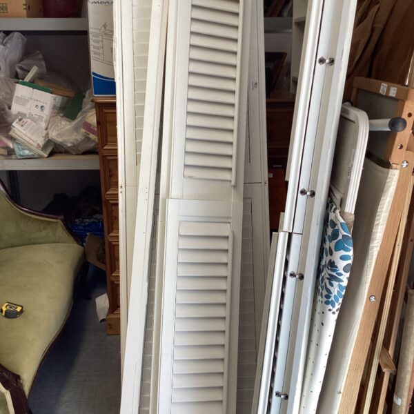 White bi-fold window shutters, approximately 77 x 25 inches.