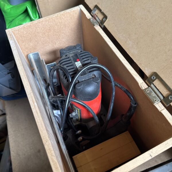 Vintage Black & Decker router inside its wooden storage box.