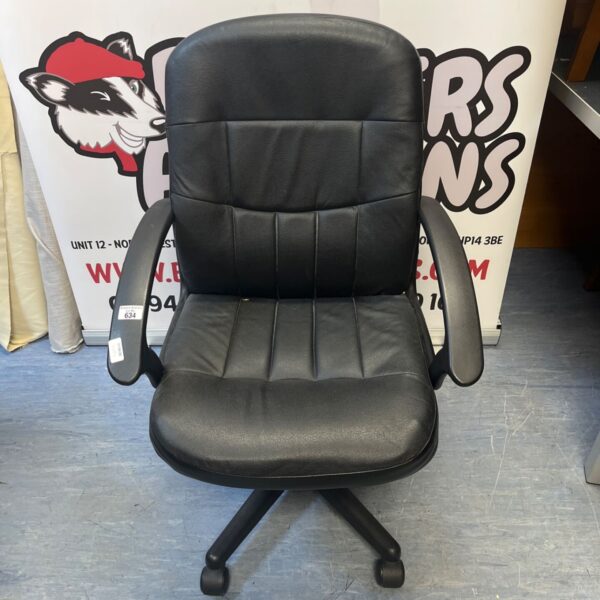 Black faux leather office chair with tiered backrest and casters.