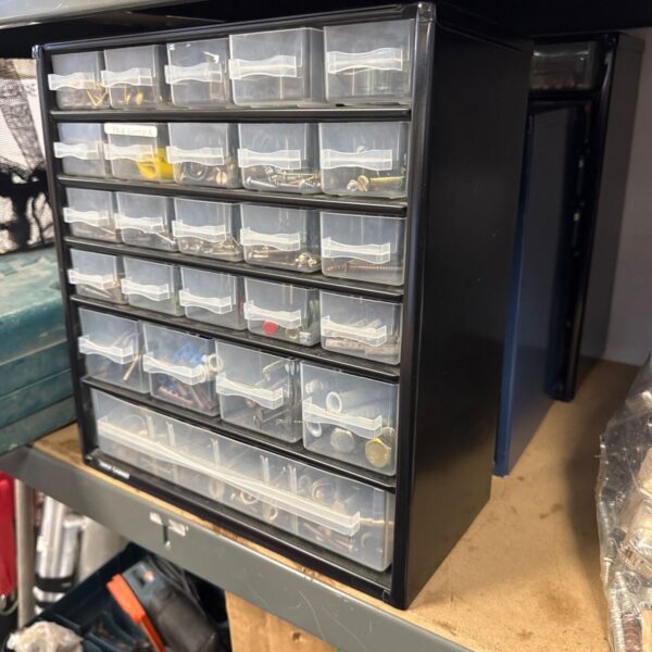 Black plastic storage drawer cabinets filled with small parts.