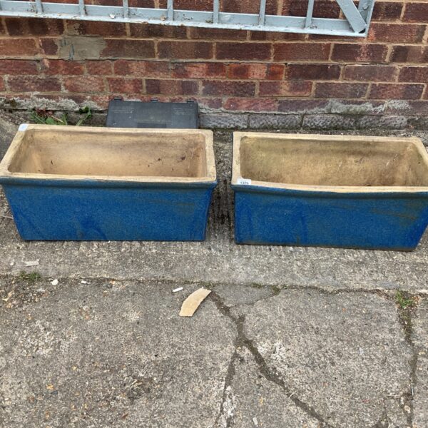 Pair of vibrant blue glazed planters for garden display.
