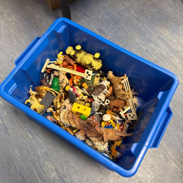 Blue plastic storage tub filled with a variety of children’s toys.