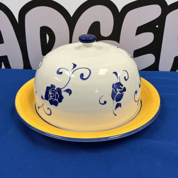 Vintage blue and yellow porcelain cheese cloche on display.