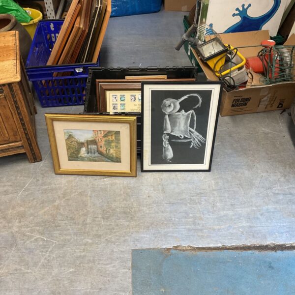 Box of artworks and prints with framed and unframed pieces.