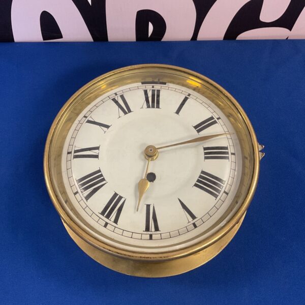 Vintage brass bulkhead clock with Roman numerals, converted to quartz.